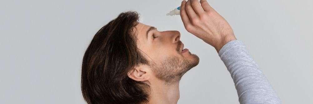 man putting in eye drops for dry eyes